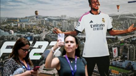 Une joueuse prend un selfie devant une publicité du jeu EA SPORTS FC 27 représentant la star française Kylian Mbappé, au salon Gamescom, à Cologne le 26 août 2026