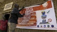 Un homme accroche une affiche de sensibilisation dans la lutte contre le virus Ebola, le 28 mai 2026 à Bunia, dans l'est de la République démocratique du Congo (RDC)