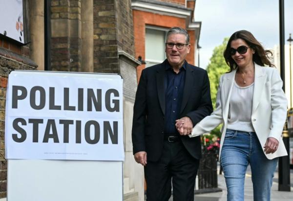 Le Premier ministre britannique Keir Starmer (g) et son épouse Victoria Starmer à l'entrée d'un bureau de vote à Londres, le 7 mai 2026