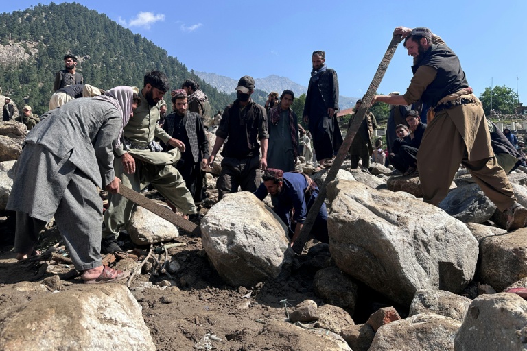 Des habitants fouillent les décombres de boutiques détruites par des crues soudaines à Parun, dans la province du Nouristan, le 21 juillet 2026 en Afghanistan
