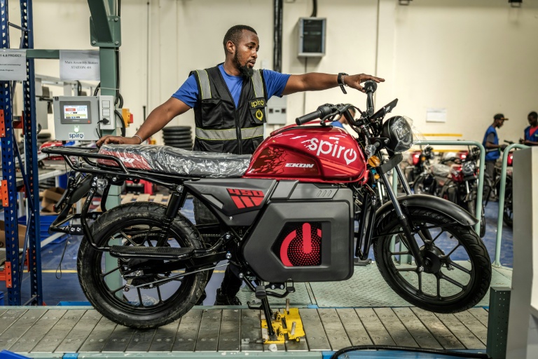 Un ouvrier inspecte une moto électrique sur une chaîne de montage du centre de production de Spiro, la plus grande entreprise de véhicules électriques d'Afrique, le 22 mai 2026 à Nairobi, au Kenya
