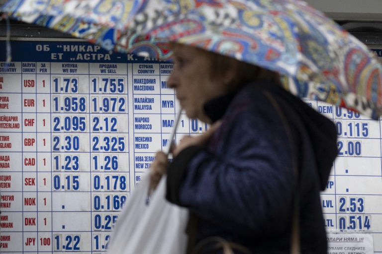 Une femme passe devant un bureau de change à Sofia, le 30 mai 2025 en Bulgarie