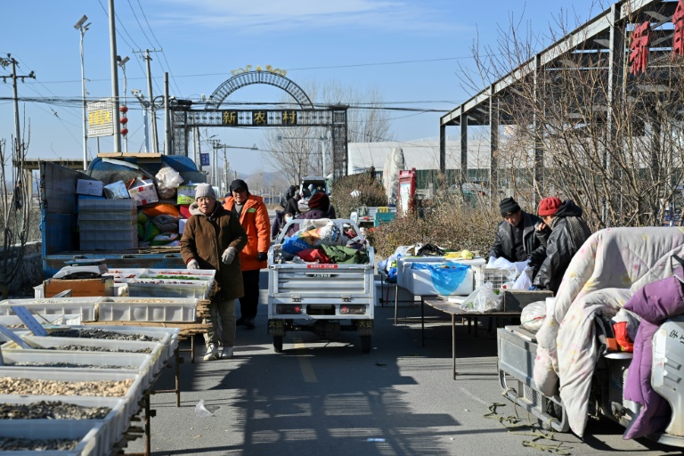 Des habitants chaudement vêtus sur un marché de la ville chinoise de Baoding, dans le district de Xushui à une centaine de kilomètres de Pékin, où les autorités ont ordonné  de remplacer les poêles à charbon par des systèmes électriques ou au gaz, le 7 janvier 2026