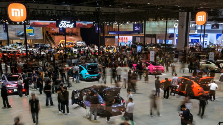 Des visiteurs sur le stand de Xiaomiau salon de l'automobile à Shanghai, le 25 avril 2025