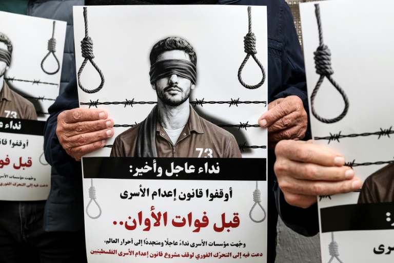 Des manifestants brandissent des pancartes sur lesquelles on peut lire 