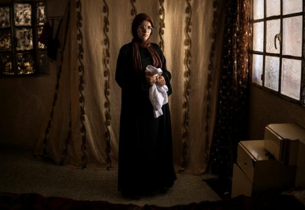 Alia al-Hallaq, la mère de Mohammed, tué à 9 ans par un soldat israélien en octobre 2025, tient le thobe de son fils, dans le village d'al-Rihiya, en Cisjordanie occupée, le 16 juillet 2026