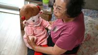 Bang Chun-ja, une Sud-Coréenne de 78 ans vivant seule, tient sa poupée IA Hyodol, le 29 avril 2026 à Yongin, en Corée du Sud