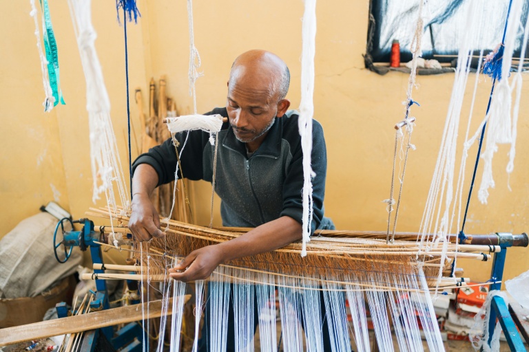 Le tisserand Gety Derza travaille sur un métier à tisser traditionnel en bois dans un atelier du quartier Shiromeda à Addis Abeba, le 7 octobre 2025 en Ethiopie