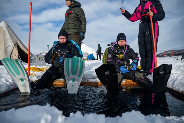 Des plongeurs participent à un stage scientifique de plongée polaire, le 14 mars 2026 sur le lac de Kilpisjärvi, à l'extrême nord-ouest de la Finlande
