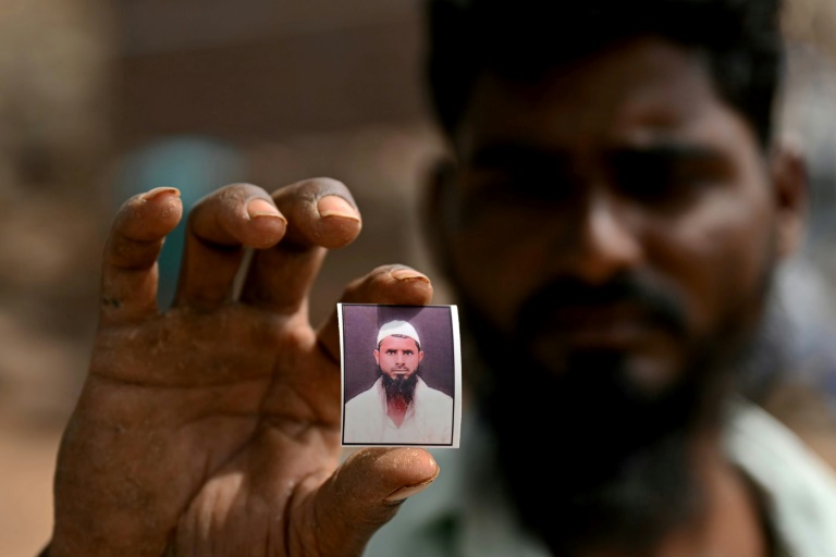 Cheikh Imran montre une photo de son frère Cheikh Latif Sheru, un agriculteur qui s'est suicidé en raison de l'accumulation de prêts financiers, sur leurs terres agricoles dans le village de Mochi Pimpalgaon, dans l'Etat du Maharashtra, le 3 mai 2025 en Inde