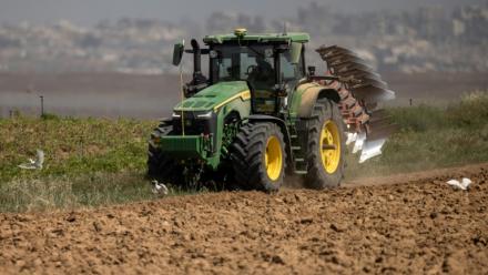 Un agriculteur en tracteur dans un champ agricole près de la frontière entre le sud d'Israël et la bande de Gaza, le 21 mai 2025