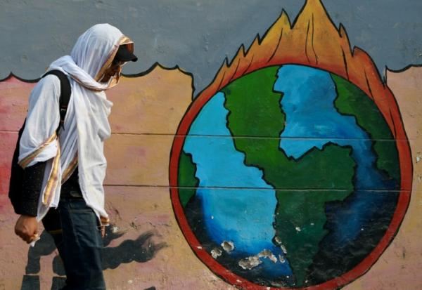 Un passant marche devant une peinture murale en pleine vague de chaleur à Varanasi, en Inde, le 9 juin 2025