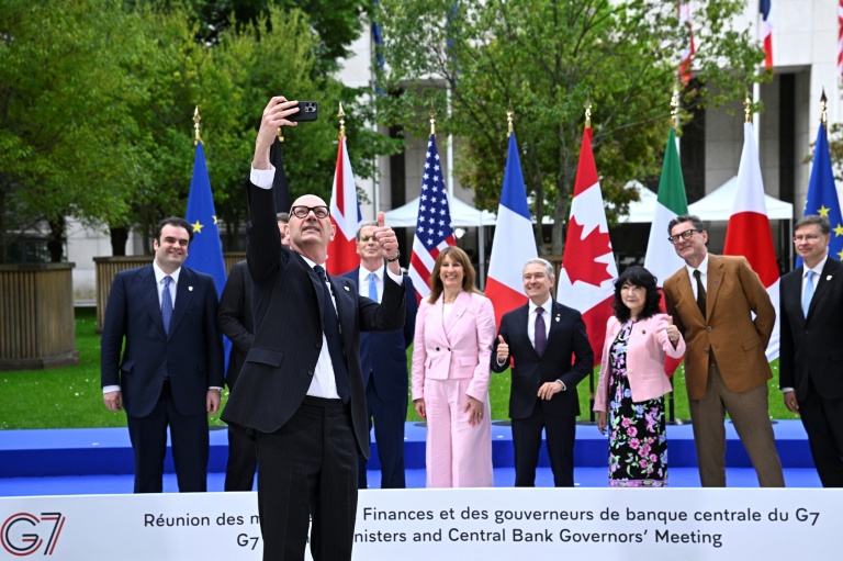 Le ministre de l'Economie Roland Lescure prend un selfie lors de la traditionnelle photo de groupe des ministres des Finances et des gouverneurs des banques centrales du G7, le 18 mai 2026 à Paris