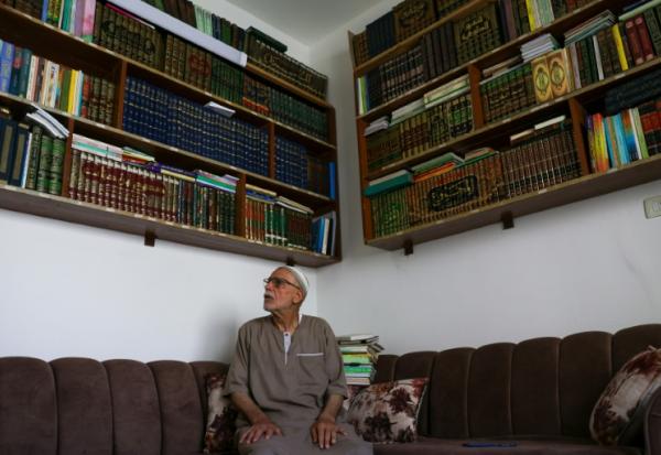 Mustafa Khaled Alwan devant sa bibliothèque, à son domicile à Homs, en Syrie, le 19 septembre 2026