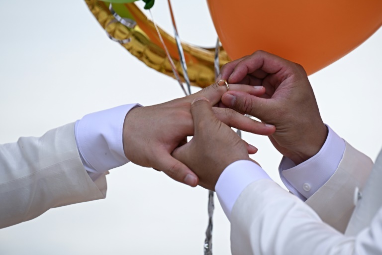 Les Chinois Song Jihan et Wang Zengyi échangent leurs alliances lors de leur mariage près de Pattaya, en Thaïlande, le 31 mai 2025