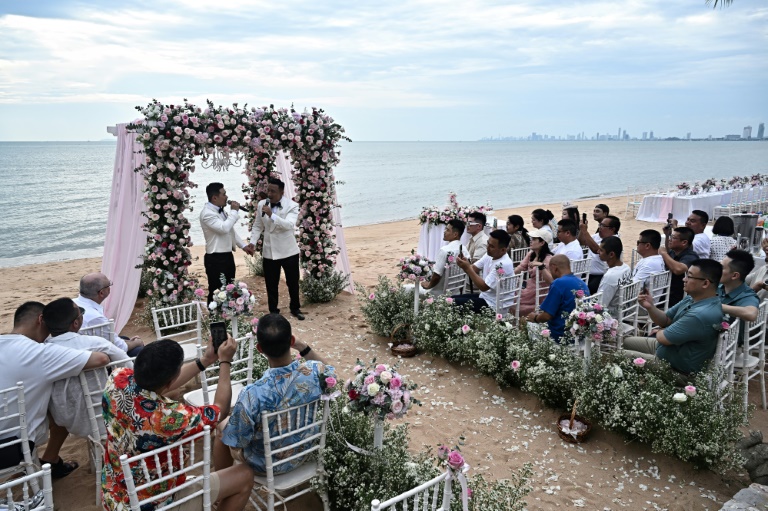 Les Chinois Song Jihan (g) et Wang Zengyi avec leurs nvités lors de leur cérémonie de mariage près de Pattaya, le 31 mai 2025 en Thaïlande