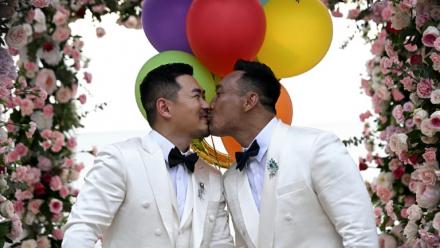 Les Chinois Song Jihan (g) et Wang Zengyi s'embrassent lors de la cérémonie de leur mariage près de Pattaya, dans la province de Chonburi, le 31 mai 2025 en Thaïlande