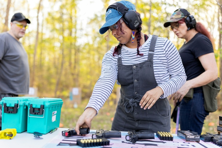 Akemi choisi un pistolet pendant un cours d'initiation au maniement des armes à feu, à Midlothian, en Virginie, le 11 avril 2026
