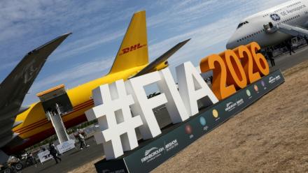 Le logo du salon aéronautique international de Farnborough devant un Boeing 777-200 (g) du géant du transport DHL et un Boeing 747 de GE Aerospace (d), lors de la journée d'ouverture à Farnborough, au sud-ouest de Londres, le 20 juillet 2026