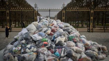 Des sacs de déchets textiles devant la porte du Palais du Luxembourg, où se trouve le Sénat lors d'une manifestation contre la fast-fashion, à Paris, le 14 mars 2025