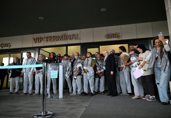 Des militants de la "flottille pour Gaza", arrêtés et expulsés par Israël, devant un terminal après leur arrivée à l'aéroport d'Istanbul, le 21 mai 2026 en Turquie