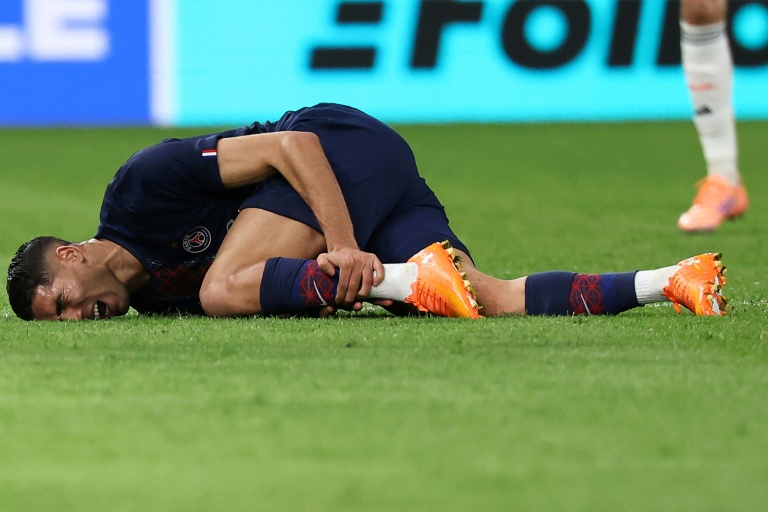 Le défenseur marocain du PSG Achraf Hakimi se tord de douleur après un mauvais tacle de l'ailier du Bayern Munich Luis Diaz, lors de l'affrontement de Ligue des champions au Parc des Princes le 4 novembre 2025