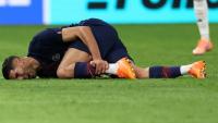 Le défenseur marocain du PSG Achraf Hakimi se tord de douleur après un mauvais tacle de l'ailier du Bayern Munich Luis Diaz, lors de l'affrontement de Ligue des champions au Parc des Princes le 4 novembre 2025