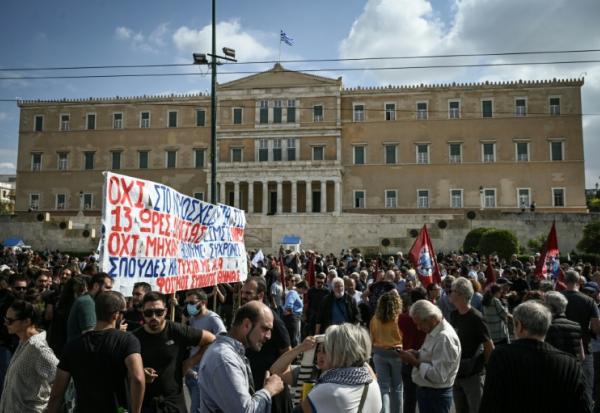 Des manifestants sont regroupés devant le Parlement grec lors d'une grève contre une réforme permettant des journées de travail de 13 heures, le 14 octobre 2025 à Athènes