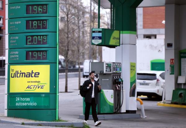 Un homme marche devant une station service à Madrid le 20 mars 2026