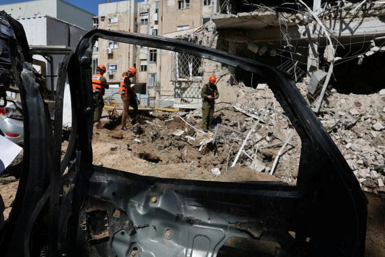Des secouristes israéliens sur les lieux où un missile iranien s'est abattu à Tel Aviv le 24 mars 2026 
