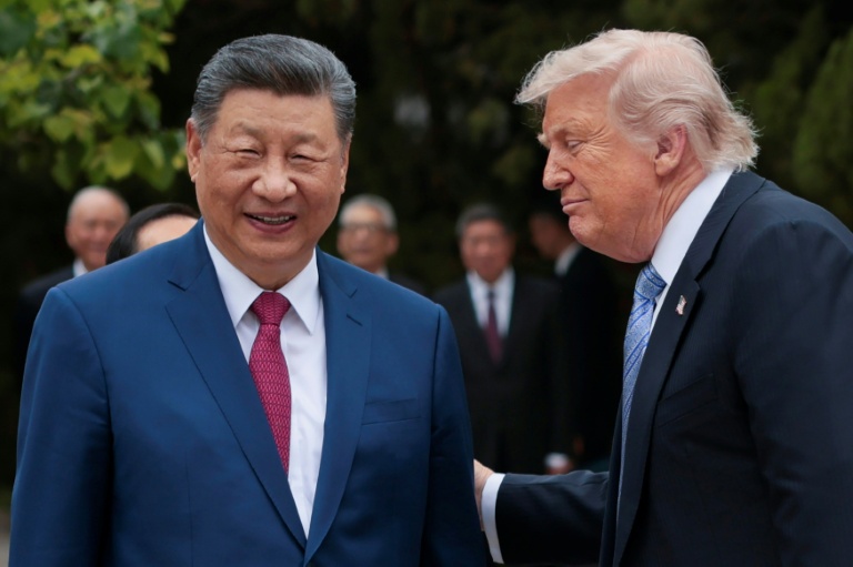 Le président américain Donald Trump (d) et le président chinois Xi Jinping à la sortie du jardin Zhongnanhai, avant de quitter Pékin, le 15 mai 2026