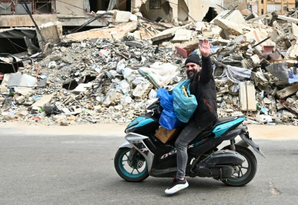 Un homme transportant des effets personnels passe à moto devant des destructions, alors que des habitants libanais regagnent leur quartier dans la banlieue sud de Beyrouth après l’entrée en vigueur, le 17 avril 2026, d’un cessez-le-feu de 10 jours avec Israël.