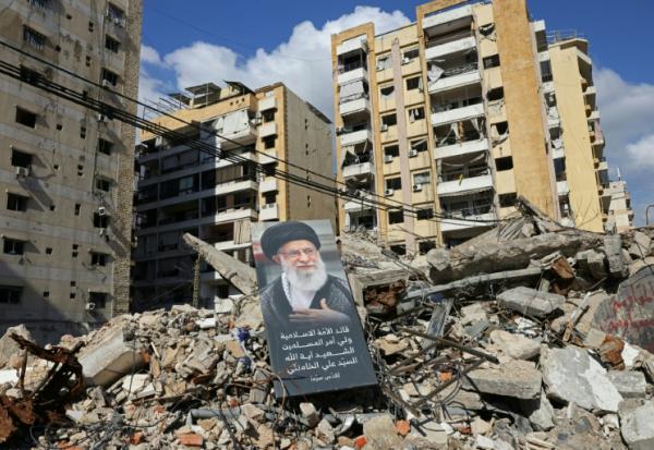 Un portrait du défunt guide suprême iranien Ali Khamenei dans les ruines de bâtiments dans la banlieue sud de Beyrouth, le 6 mai 2026 au Liban