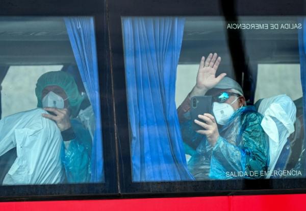 Des passagers du navire de croisière MV Hondius, touché par l'hantavirus, à bord d'un bus militaire, le 10 mai 2026 sur l'île espagnole de Tenerife
