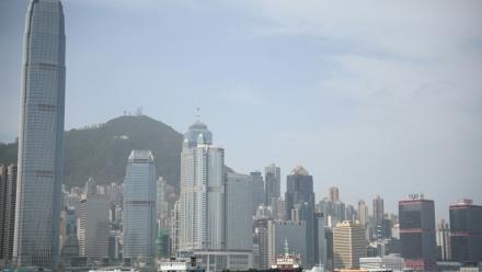 Une barge porte-conteneurs à vide traverse le port de Victoria à Hong Kong, le 16 avril 2025