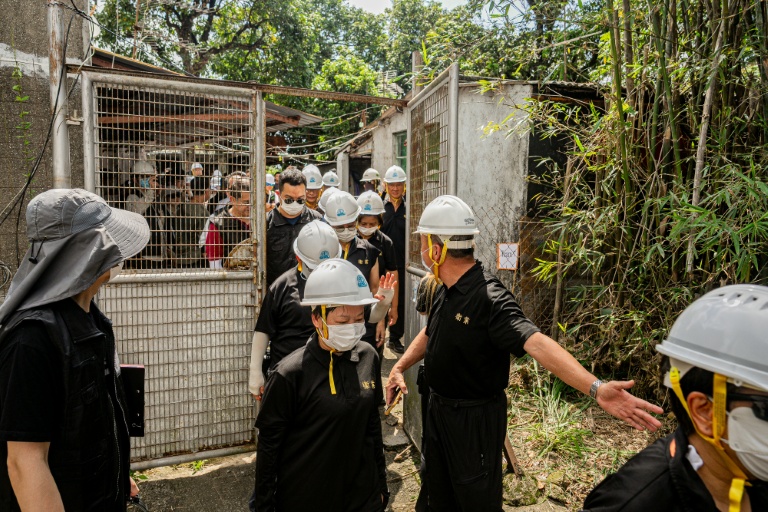 Des agents du service des Terres de Hong Kong accompagnés par des policiers pénètrent dans la propriété d'un habitant de Kwu Tung, dont le village doit être démoli pour faire place à un 
projet de pôle technologique, le 23 juin 2026 dans les Nouveaux Territoires à Hong Kong