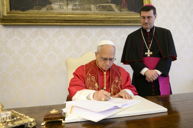 Photo, prise le 15 mai 2026 et diffusée le 25 mai 2025 par The Vatican Media, montre le pape Léon XIV en train de signer au Vatican sa première lettre encyclique, 