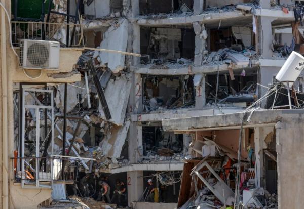 Des secouristes israéliens fouillent les décombres d'un bâtiment touché par des tirs de missiles iraniens dans la ville côtière de Bat Yam, au sud de Tel-Aviv, le 15 juin 2025