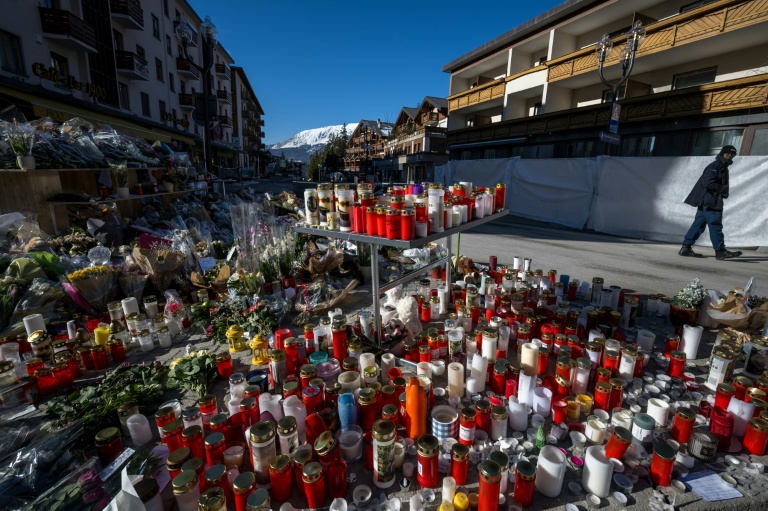 Un homme passe devant un mémorial aux victimes de l'incendie du bar Constellation, à Crans-Montana en Suisse le 6 janvier 2026