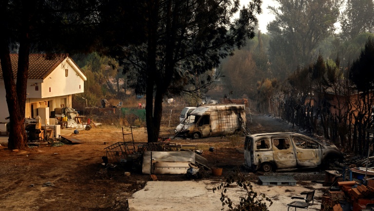 Des carcasses de voitures calcinées dans une propriété après un incendie de forêt à Pelayos de la Presa, à environ 65 km à l'ouest de Madrid, le 26 juillet 2026 