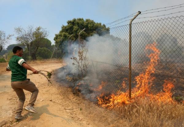 Un habitant essaie d'éteindre un incendie sur sa propriété près de San Martin de Valdeiglesias, à environ 70 km à l'ouest de Madrid, le 26 juillet 2026