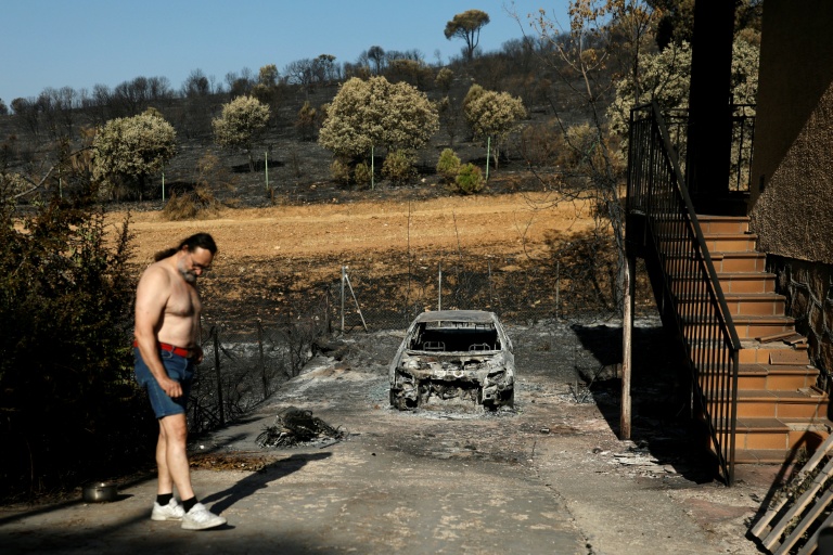 Un homme se tient à côté de sa voiture calcinée sur sa propriété, dévastée par un incendie de forêt dans le lotissement d'Encinar del Alberche, à Villa del Prado, au sud-ouest de Madrid, en Espagne, le 30 juillet 2026