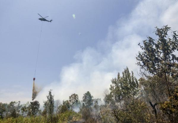 Un hélicoptère largue de l’eau sur des forêts et des terres en feu dans les zones de Tegal Arum et Guntung Damar, à Banjarbaru, dans la province de Kalimantan du Sud, en Indonésie, le 19 septembre 2026