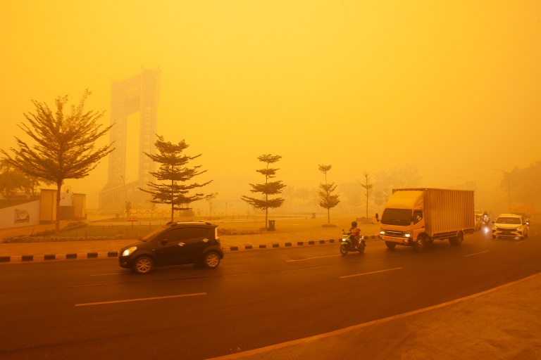 Des automobilistes circulent dans une épaisse fumée due aux incendies à Palangkaraya, dans le Kalimantan central, en Indonésie, le 14 octobre 2026