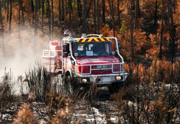 Un camion de pompiers au milieu d'une végétation en partie détruite par un incendie à Lège-Cap-Ferret, en Gironde, le 1er août 2026 