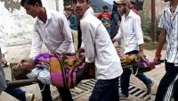 Des hommes transportent un blessé dans une civière à l'hôpital de Kishtwar en Inde le 14 août 2025 après des inondations au Cachemire 