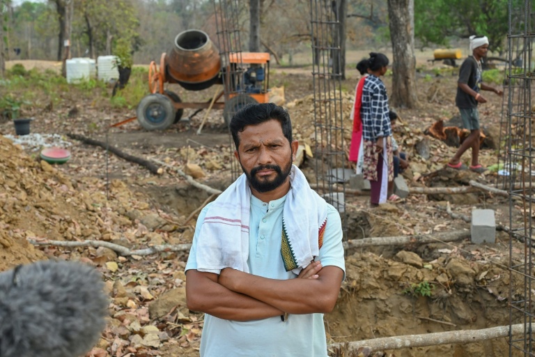 Umesh Sundam, dont le frère a été tué par les forces de sécurité après avoir été, à tort, qualifié d'insurgé, pose sur le site d'un grenier gouvernemental en construction à Dantewada, dans l'Etat de Chhattisgarh, le 31 mars 2026 en Inde