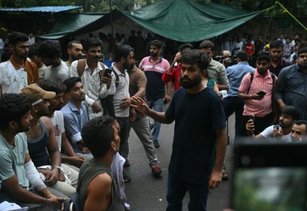 Abhijeet Dipke, fondateur du "parti des cafards", s'entretient le 21 juillet 2026 avec des manifestants blessés lors d'une mobilisation réclamant la démission du ministre indien de l'Education, Dharmendra Pradhan, en raison d'irrégularités présumées dans l'examen NEET, à New Delhi.