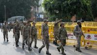 Les membres des forces de sécurité arrivent pour prendre leur poste à un point de contrôle temporaire à New Delhi, le 11 octobre 2026