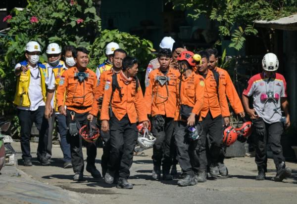 Des membres des équipes de secours quittent le site de l'effondrement de l'internat islamique Al Khoziny à Sidoarjo, dans l'est de Java, le 6 octobre 2025 en Indonésie